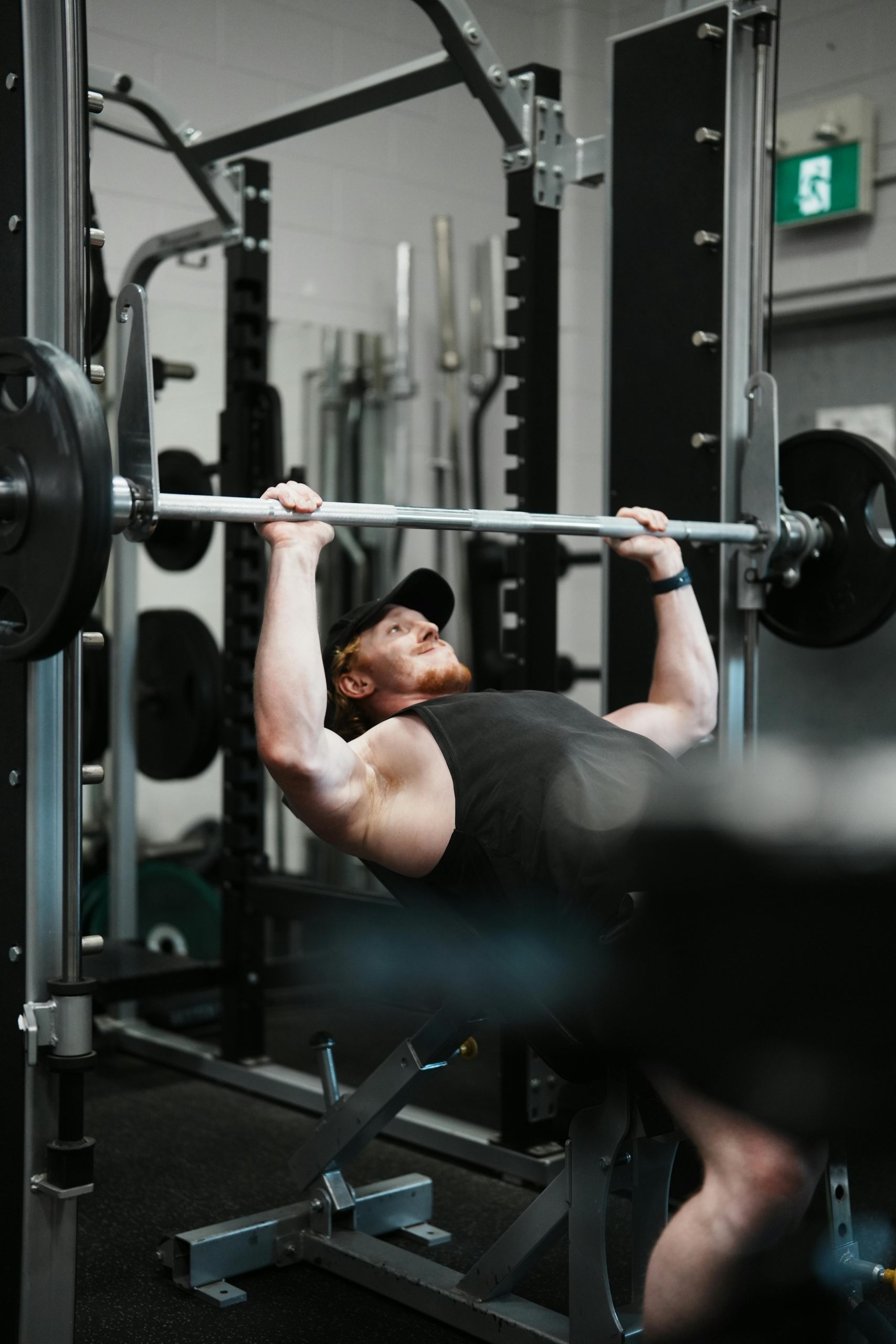 Mann beim Bankdrücken im Fitnessstudio
